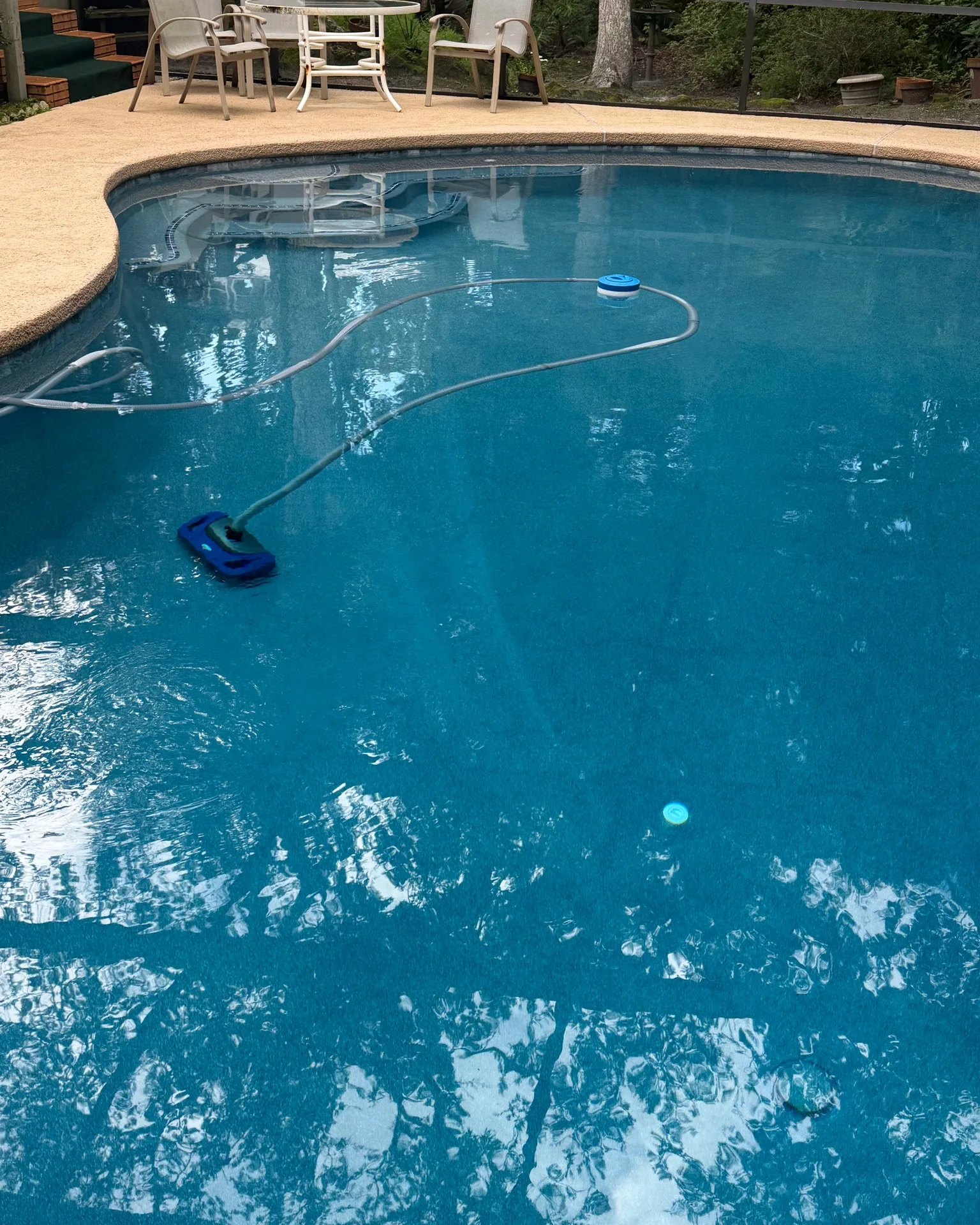 Clear blue pool with a robotic cleaner at a Jacksonville home
