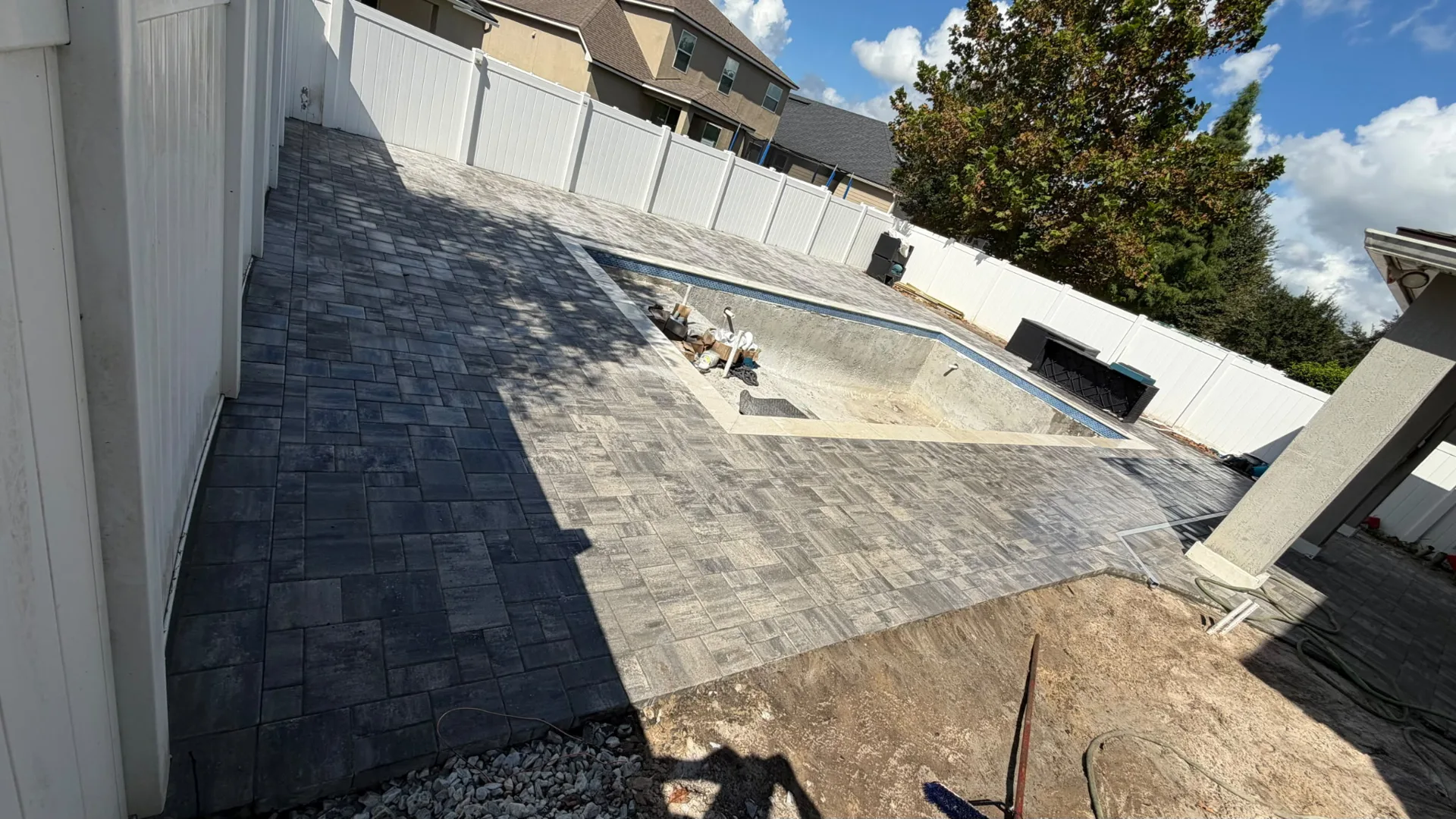 Paver deck installed around a pool under construction in Jacksonville
